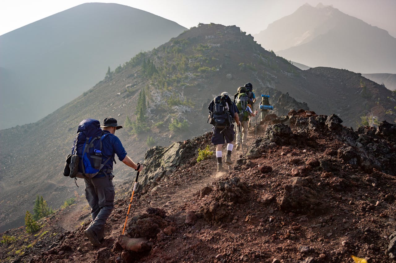 our-story Group of hikers trekking on a rugged mountain trail in Oregon's scenic outdoors.